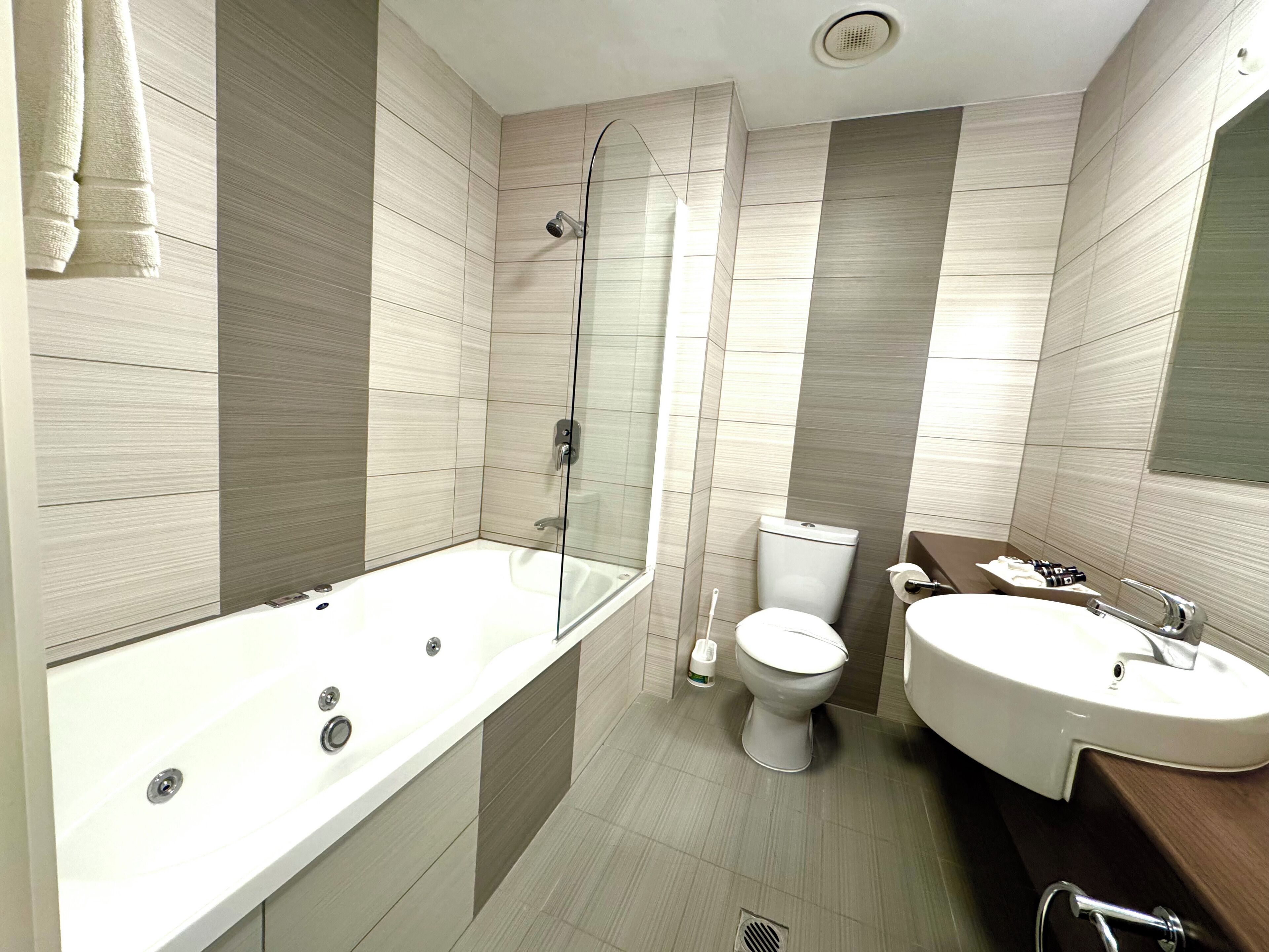 A modern bathroom with a bathtub, toilet, and sink.