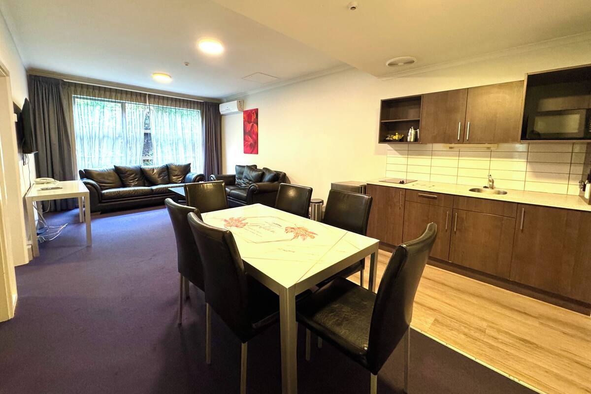 A modern apartment with a dining area, kitchen, and living room.