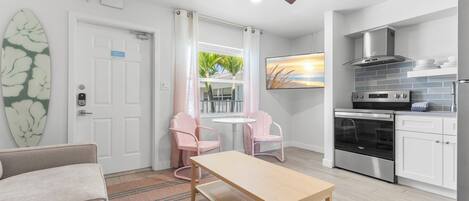 A modern kitchen with stainless steel appliances, a ceiling fan, and a dining area with a table and chairs.