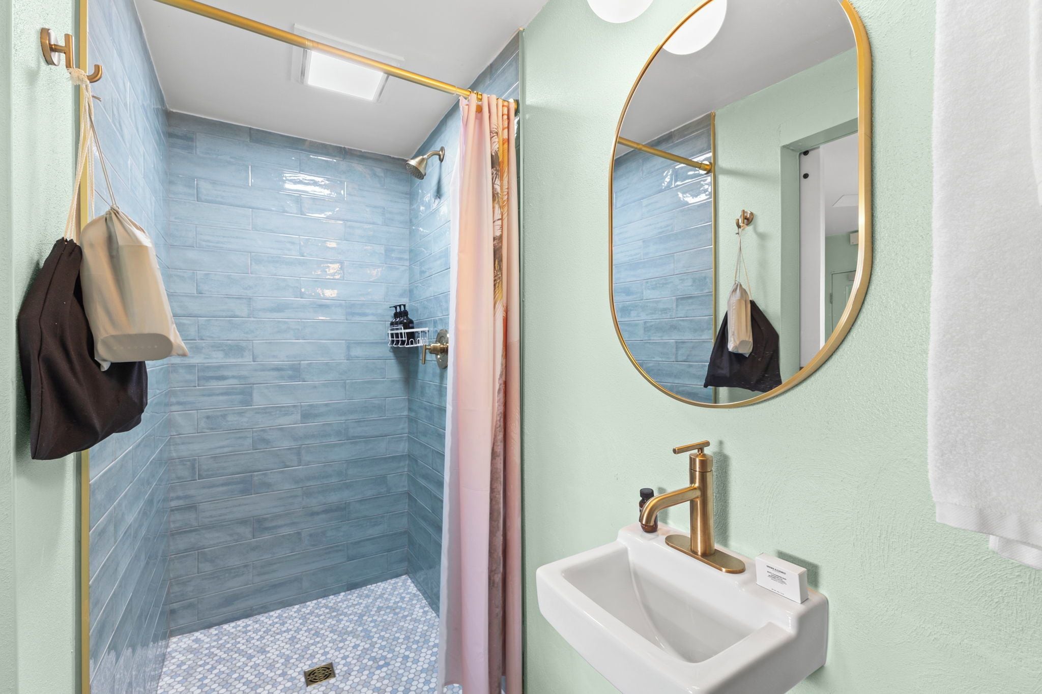 Ein Badezimmer mit Dusche, Waschbecken und Spiegel.