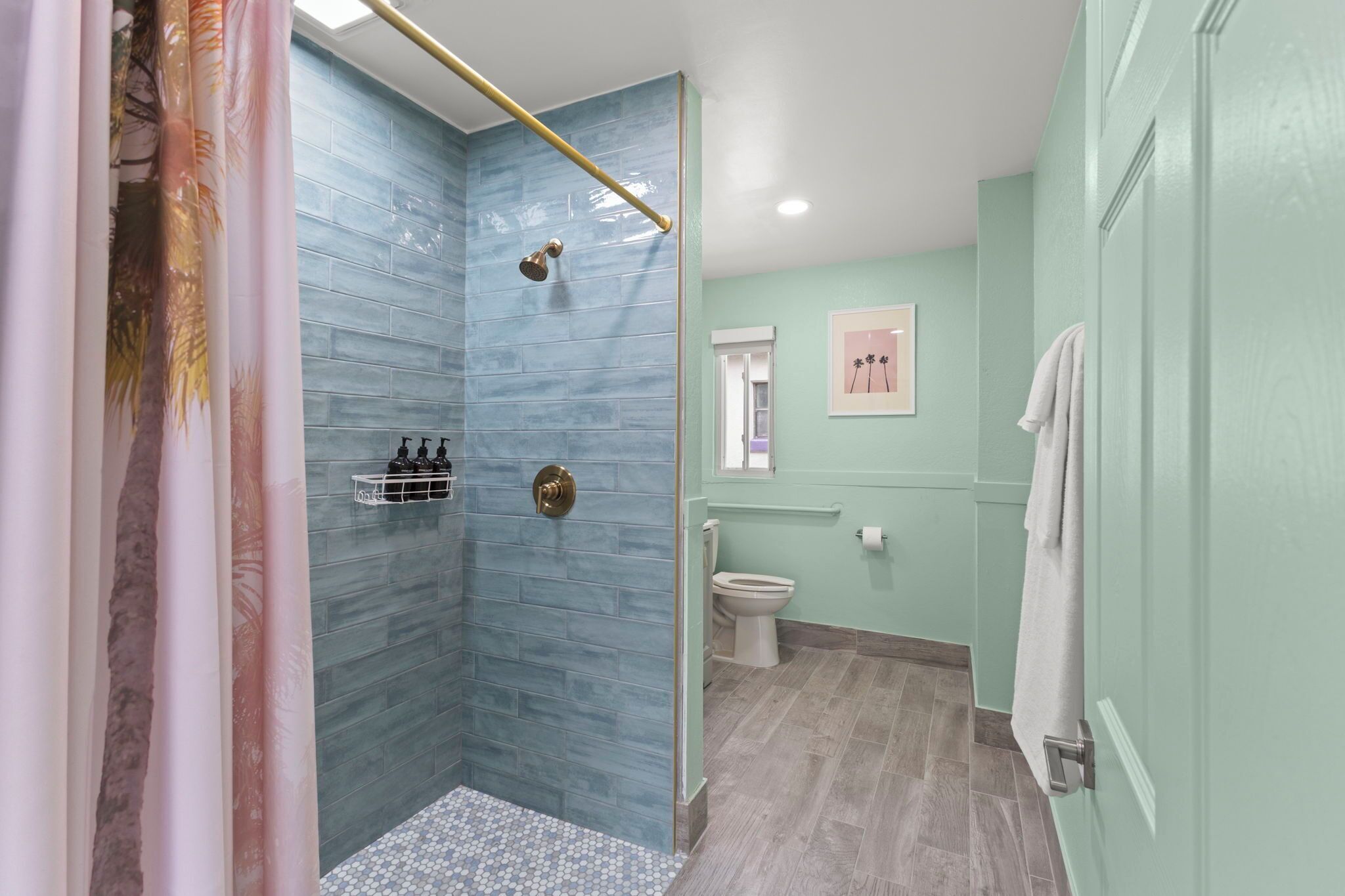 Een badkamer met douche, toilet en wastafel.