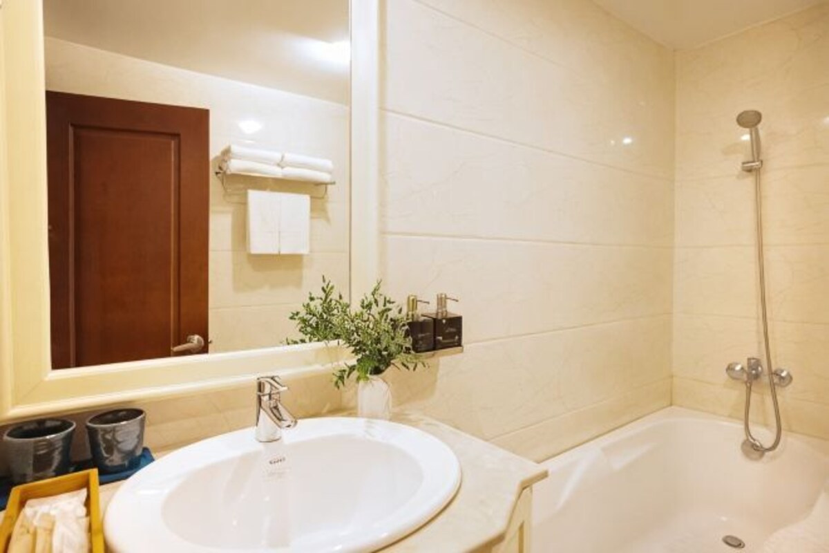 Un baño con lavabo, espejo y ducha.