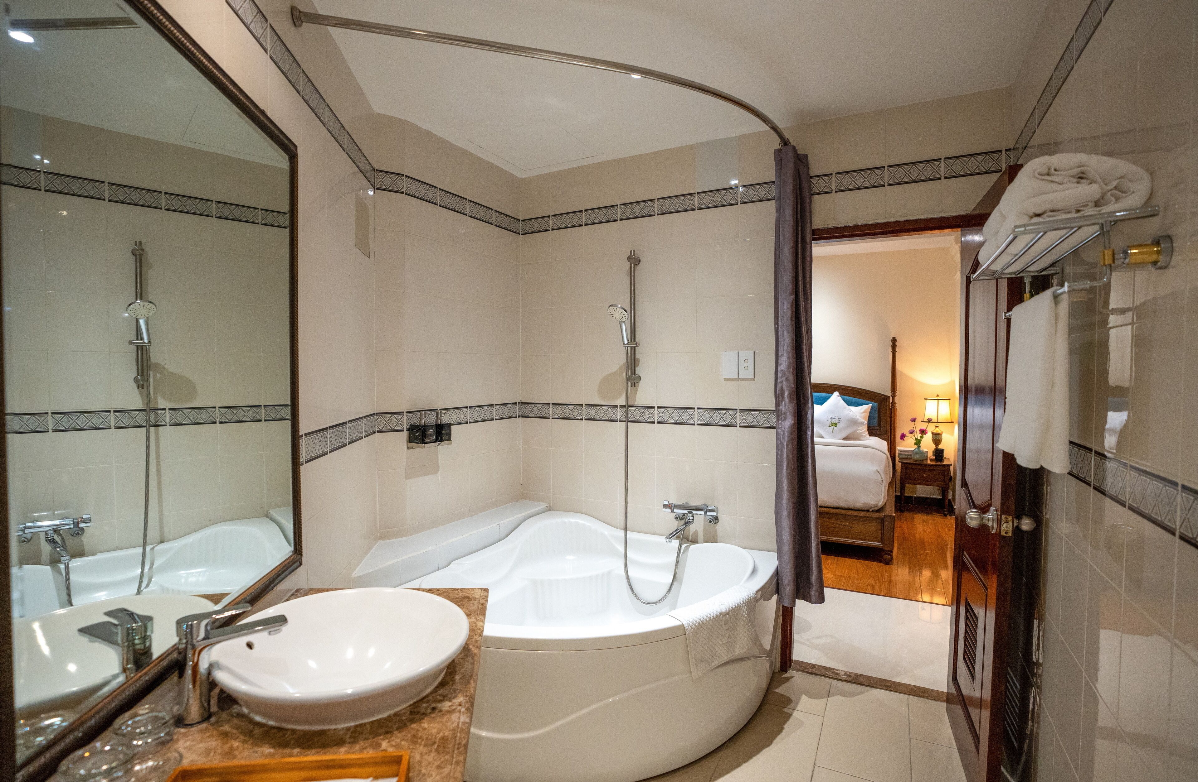 A modern bathroom with a large bathtub, a separate sink, and a shower.