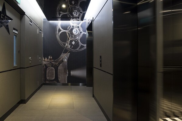 A modern elevator with a metallic finish and a geometric design on the wall.