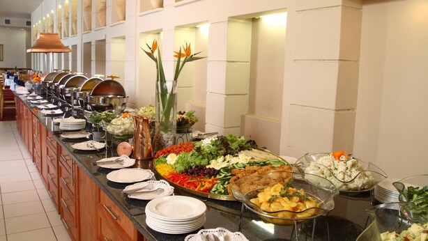 A buffet setup with various food items and dishes. - Apollo Hotel (Randburg)