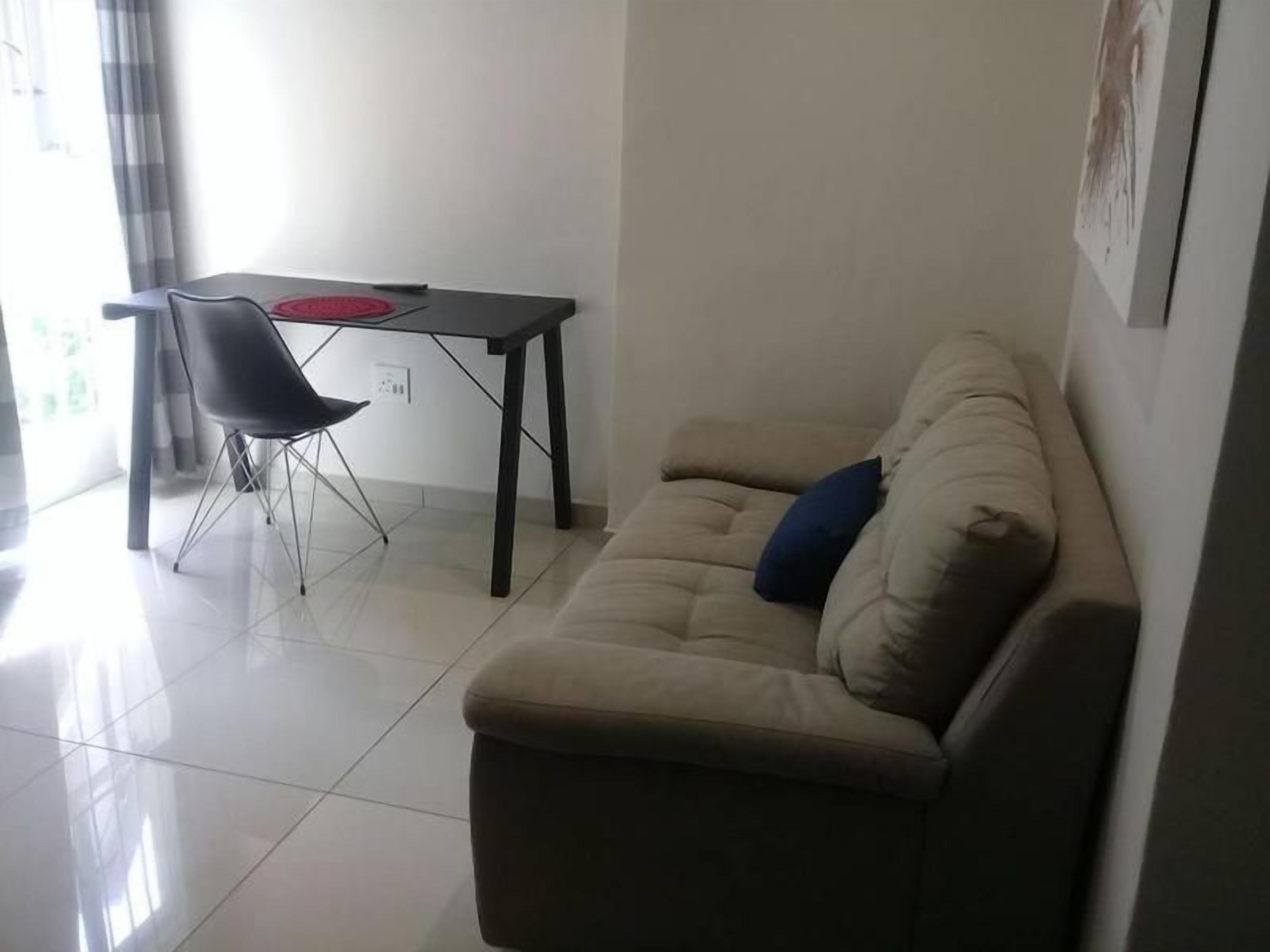 Una sala de estar con un sofá, una mesa de comedor y una silla.