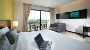 A hotel room with a bed, a laptop, a TV, a sofa, and a balcony with a view. - Simplitel (Karon)