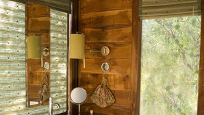 Une salle de bain en bois avec une grande fenêtre, un lavabo et un autel décoratif.