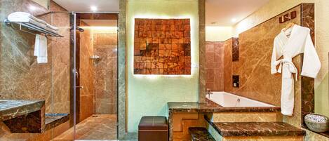 A modern bathroom with a walk-in shower, a bathtub, and a vanity with a marble countertop.