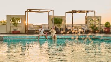 Una piscina al aire libre, camas de piscina gratis, sombrillas