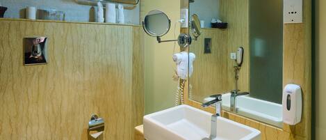 A modern bathroom with a toilet, sink, and mirror.