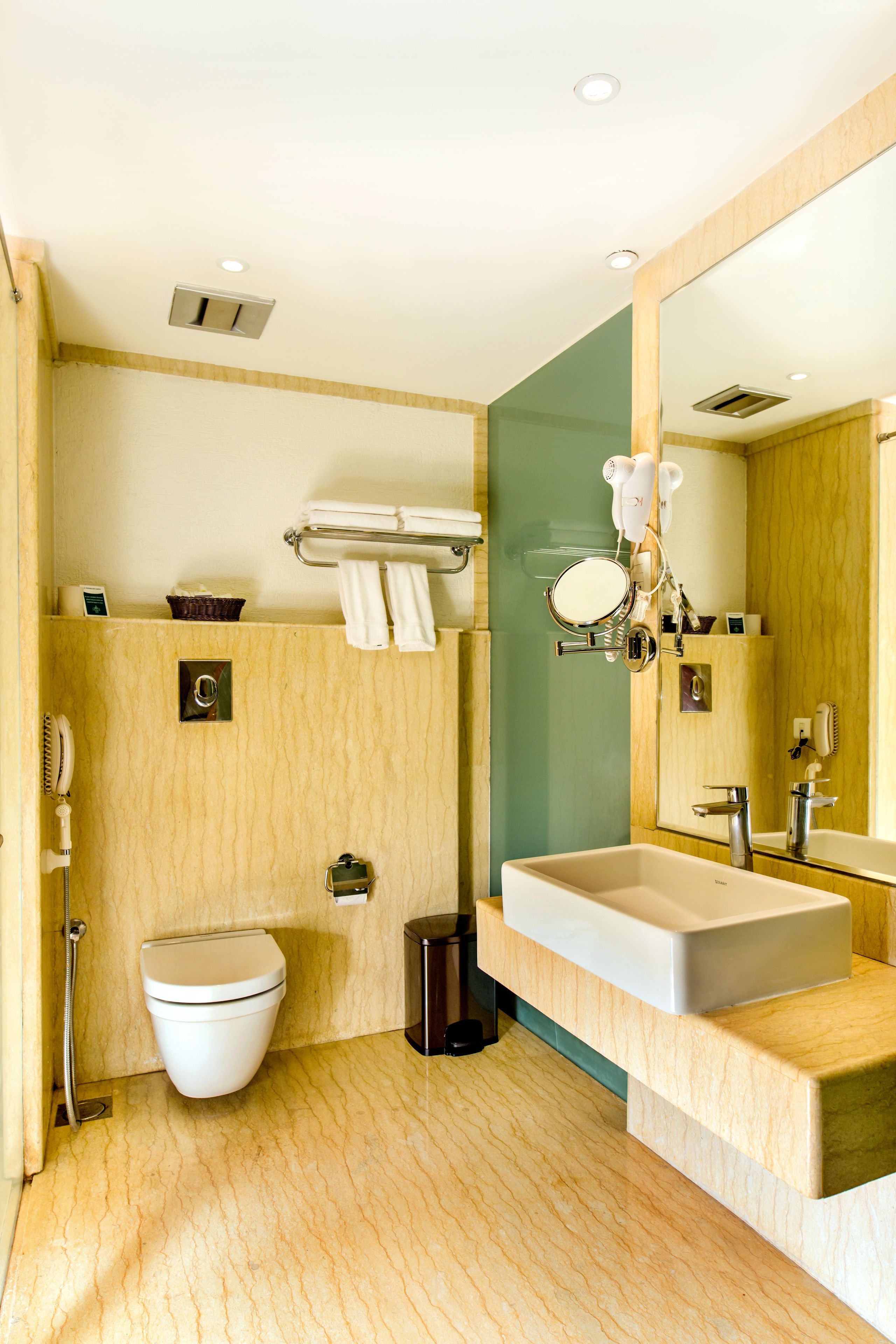 A modern bathroom with a toilet, sink, and mirror.