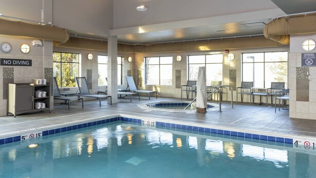 An indoor swimming pool with clear water, lounge chairs, and a 'NO DIVING' sign. - Residence Inn Midland Marriott (Midland)