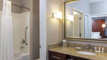 A bathroom with a shower, toilet, sink, and vanity.