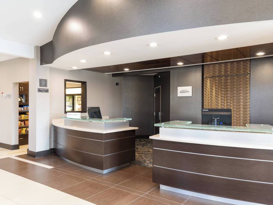 A reception area with two glass-top counters, a dark wood finish, and a modern design.