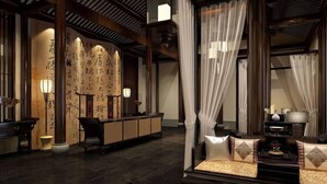 A traditional interior with a reception desk, seating area, and calligraphy on the wall. - Dayu Kaiyuan (Shaoxing)