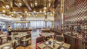 A spacious restaurant with wooden tables and chairs, hanging lanterns, and a large windowed wall. - Dayu Kaiyuan (Shaoxing)