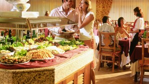 A buffet setup with various food items and a serving staff.