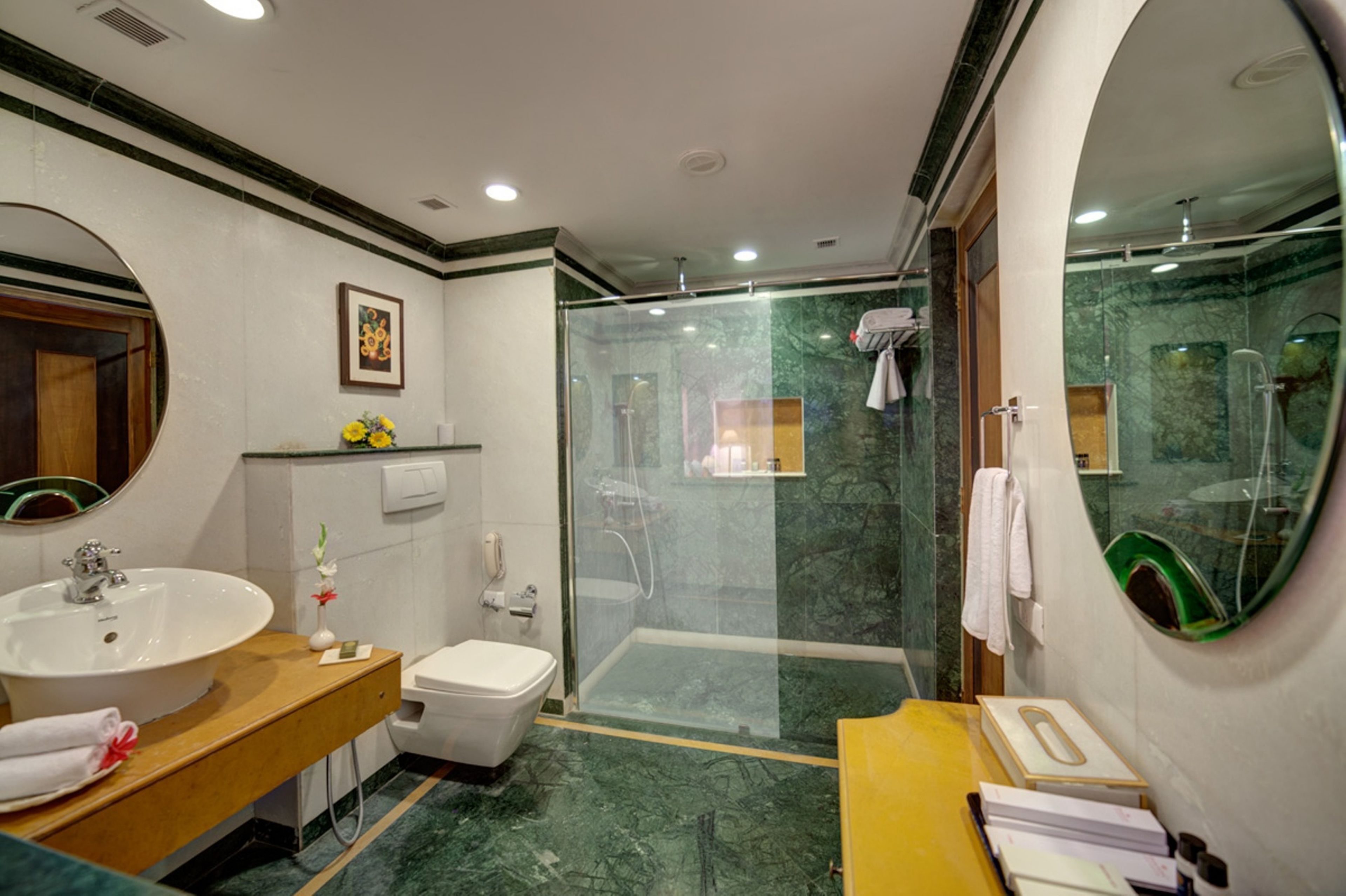 Un baño moderno con un lavamanos grande, inodoro y zona de ducha con paredes de vidrio.