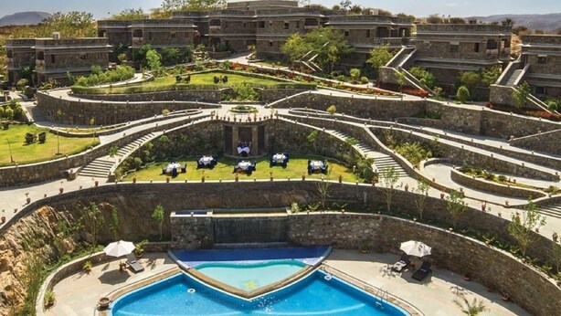 Een resort met een centraal gelegen zwembad, meerdere gastenkamers en een aangelegde tuin.