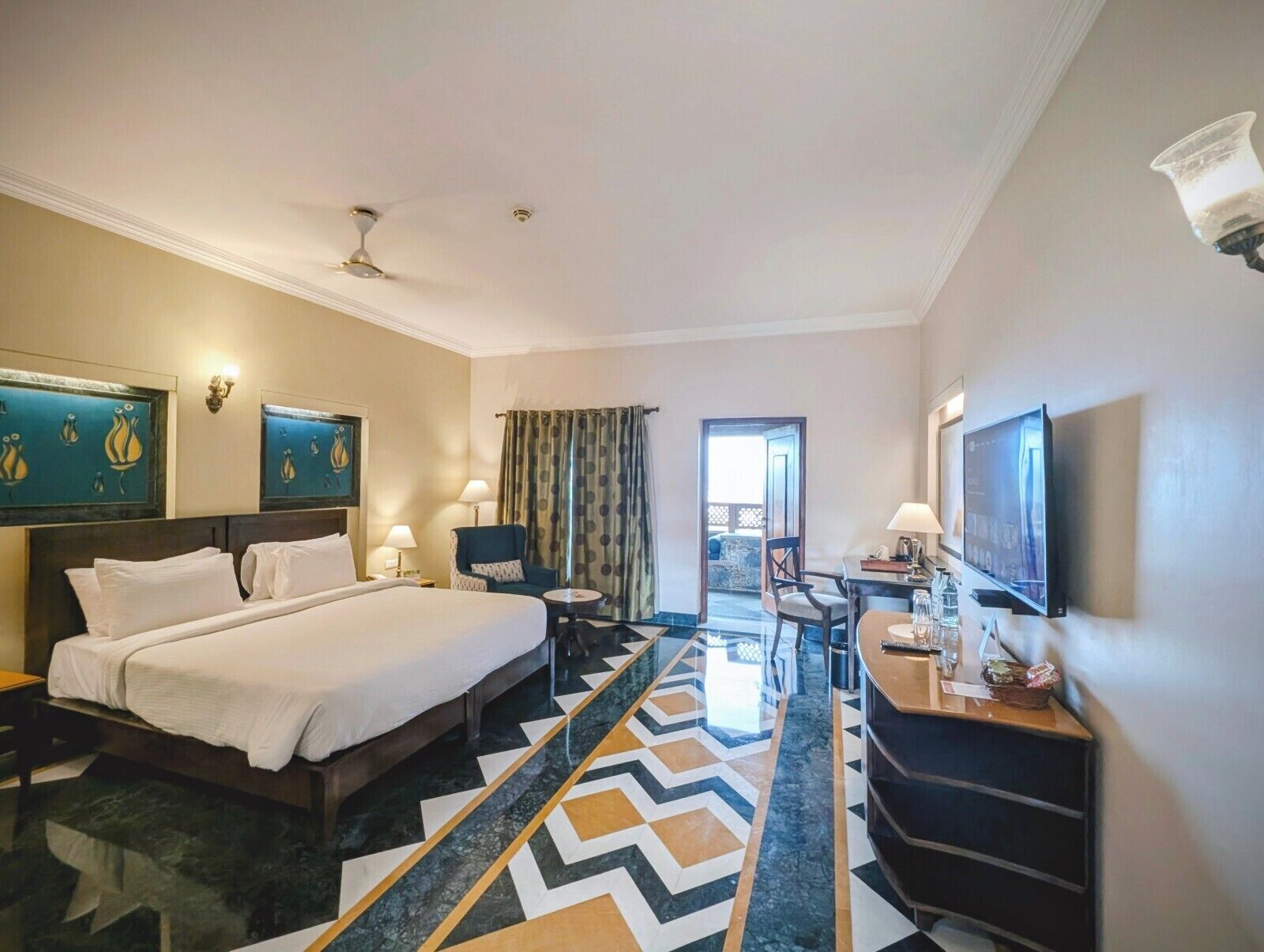 Una camera d'hotel con un letto grande, una scrivania, una televisione e vista all'esterno.