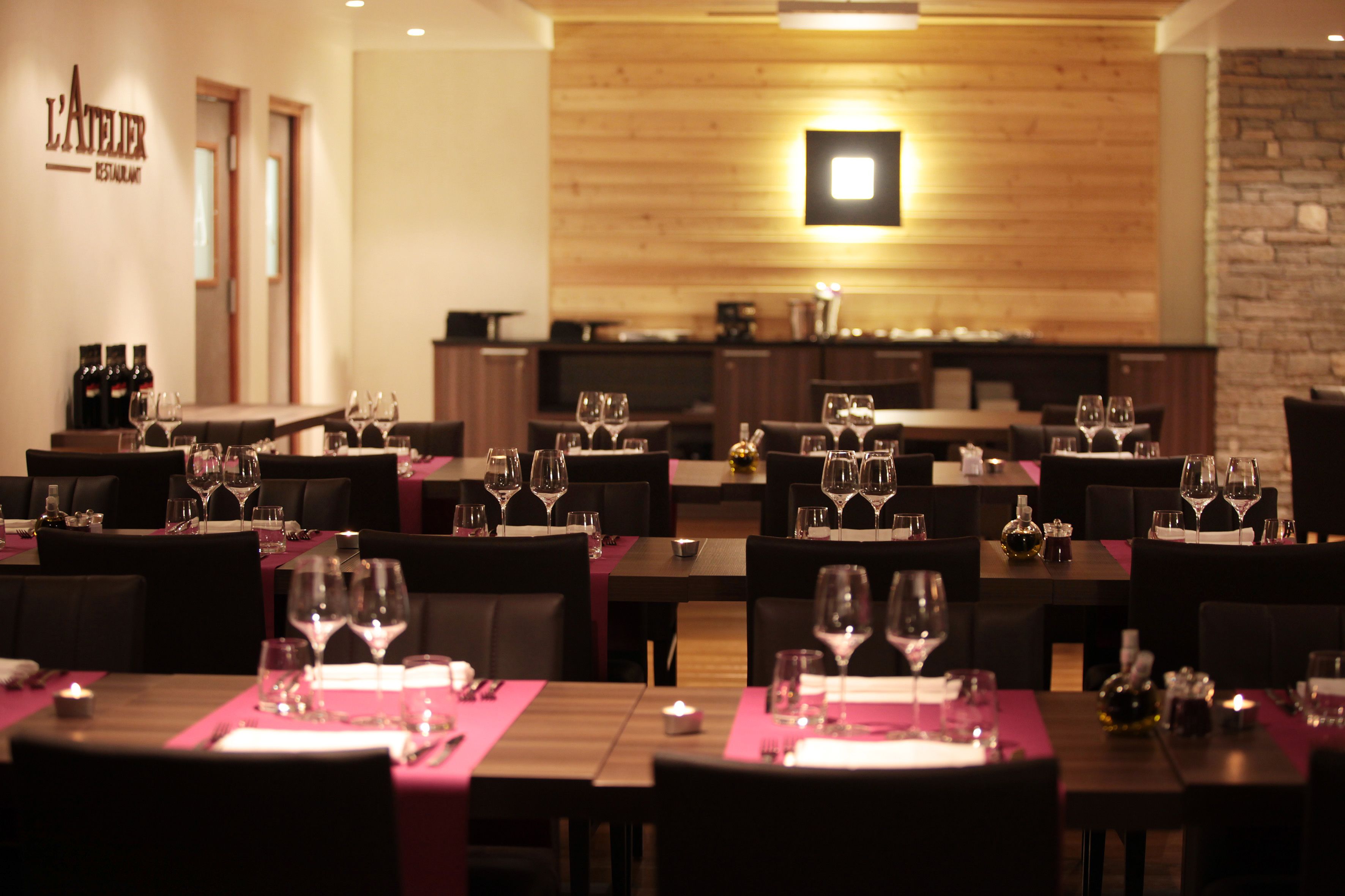 Ein Restaurant mit mehreren gedeckten Tischen, an jedem Tisch mit Weingläsern und Besteck.