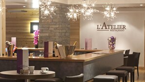 A restaurant interior with a wooden counter, bar area, and seating arrangement. - Le Chalet du Mont Vallon Spa Resort (Les Belleville)
