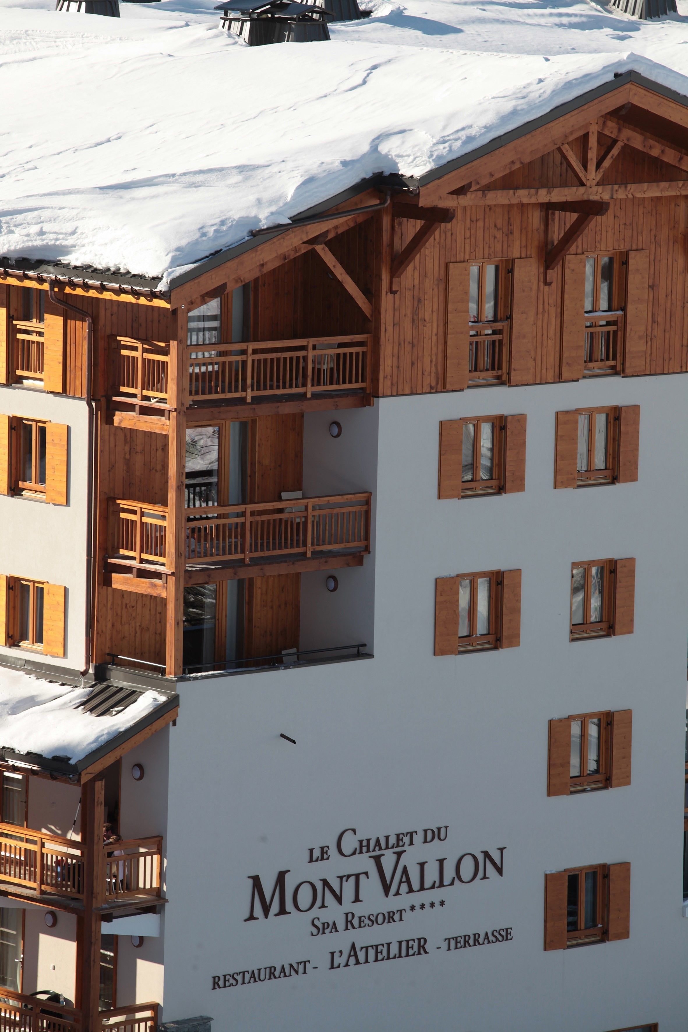 A multi-story building with wooden balconies and a sign indicating it is a spa resort.