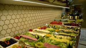 A buffet with various food items and utensils.