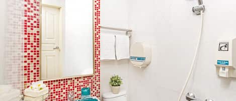A bathroom with a white sink, a mirror, a shower, and a toilet.