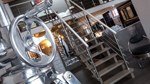 Een modern interieur met een metalen trap en een chromen motorfiets.