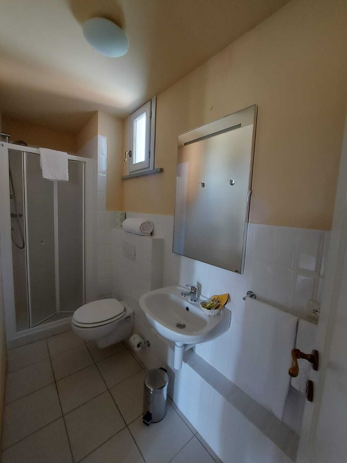 Un baño pequeño con inodoro, lavabo y ducha.