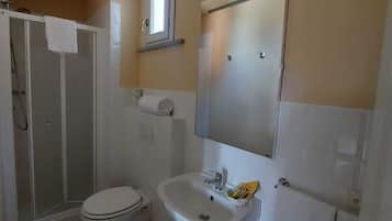 Un baño pequeño con inodoro, lavabo y ducha.