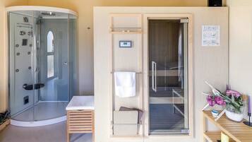 Enjoy a refreshing shower in the bathroom, featuring a glass-enclosed shower area and a wooden vanity.