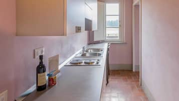 A kitchen with a countertop, a wine bottle, and a can of food.
