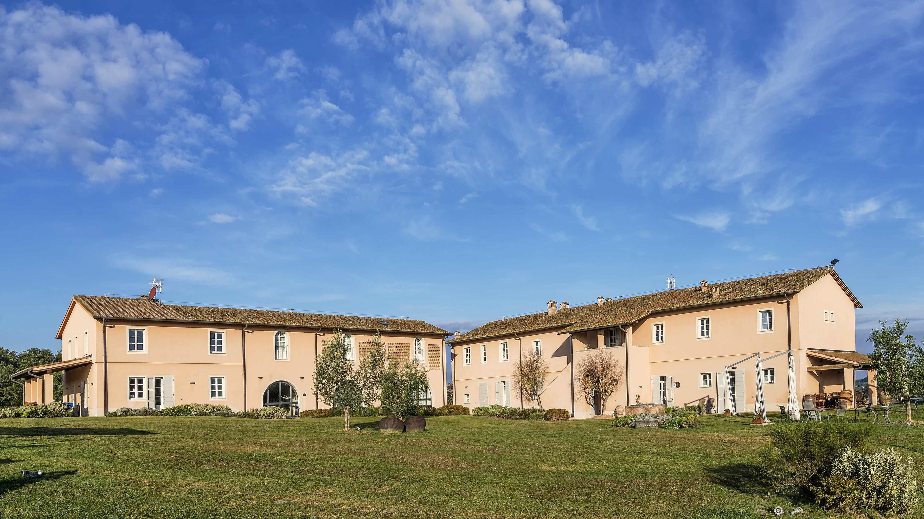 A two-story building with a symmetrical facade, large windows, and a central entrance.