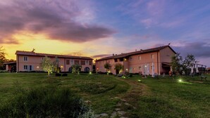 A large building with multiple sections, a well-maintained lawn, and outdoor seating areas. - Le Sodole Country Resort & Golf (Pontedera)