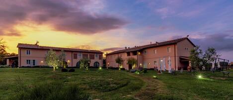 A large building with multiple sections, a well-maintained lawn, and outdoor seating areas.