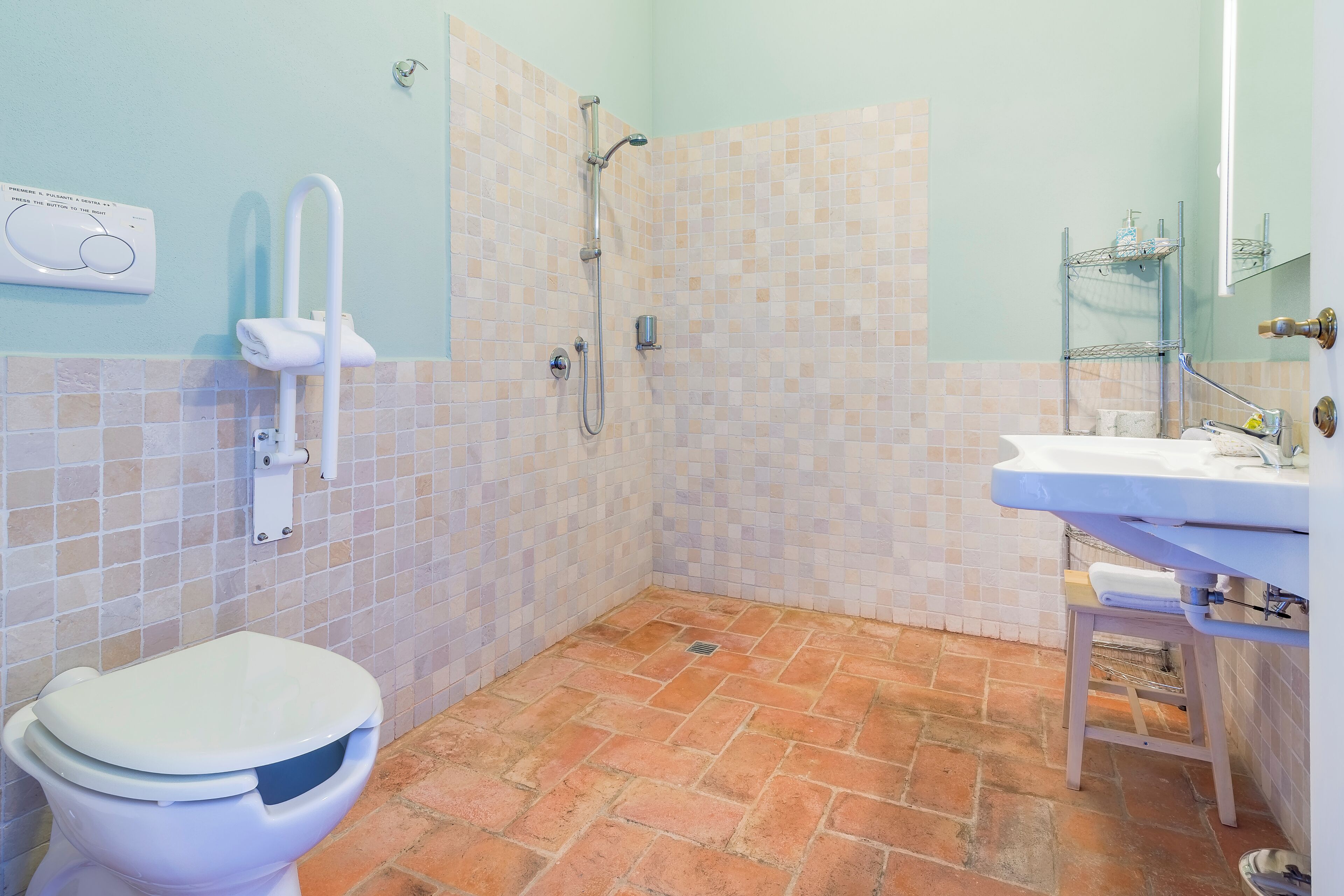 A bathroom with a toilet, shower, and sink.
