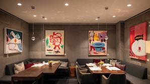 A modern hotel lobby with seating arrangements, artwork on the walls, and a clean, contemporary design. - Hotel Aurelio (Lech am Arlberg)