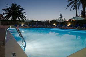 Una piscina al aire libre, sombrillas, tumbonas