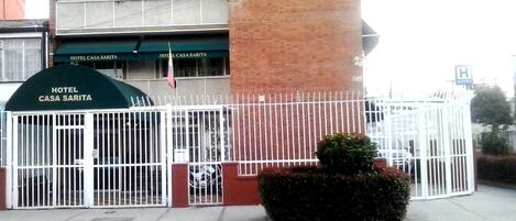 A multi-story building with a gated entrance labeled "Hotel Casa Sarita."