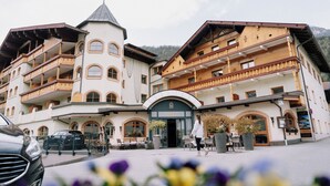 A multi-story hotel with balconies, a central entrance, and outdoor seating. - Alpin Resort Stubaierhof (Fulpmes)