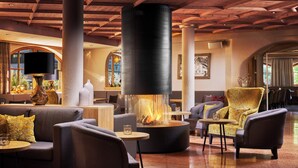 A spacious lobby with a central fireplace, comfortable seating, and a modern design. - Alpin Resort Stubaierhof (Fulpmes)