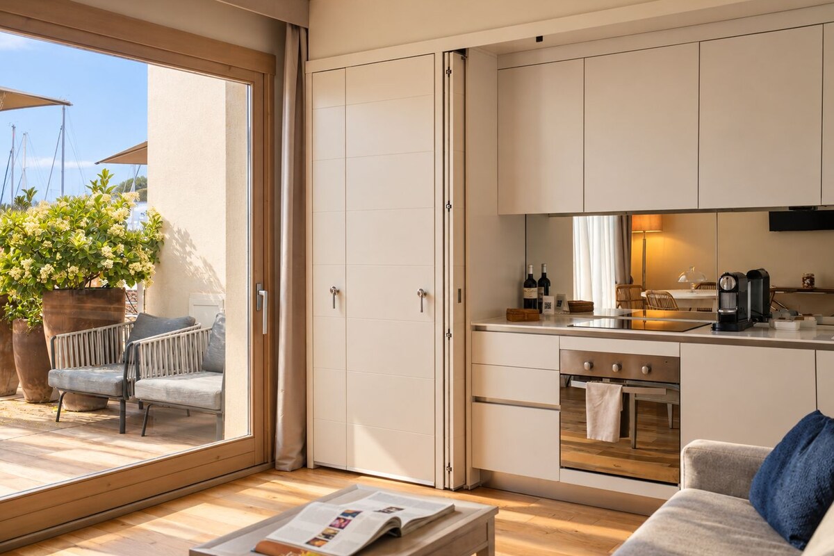 A modern kitchen with a built-in oven and a dining area with a table and chairs.