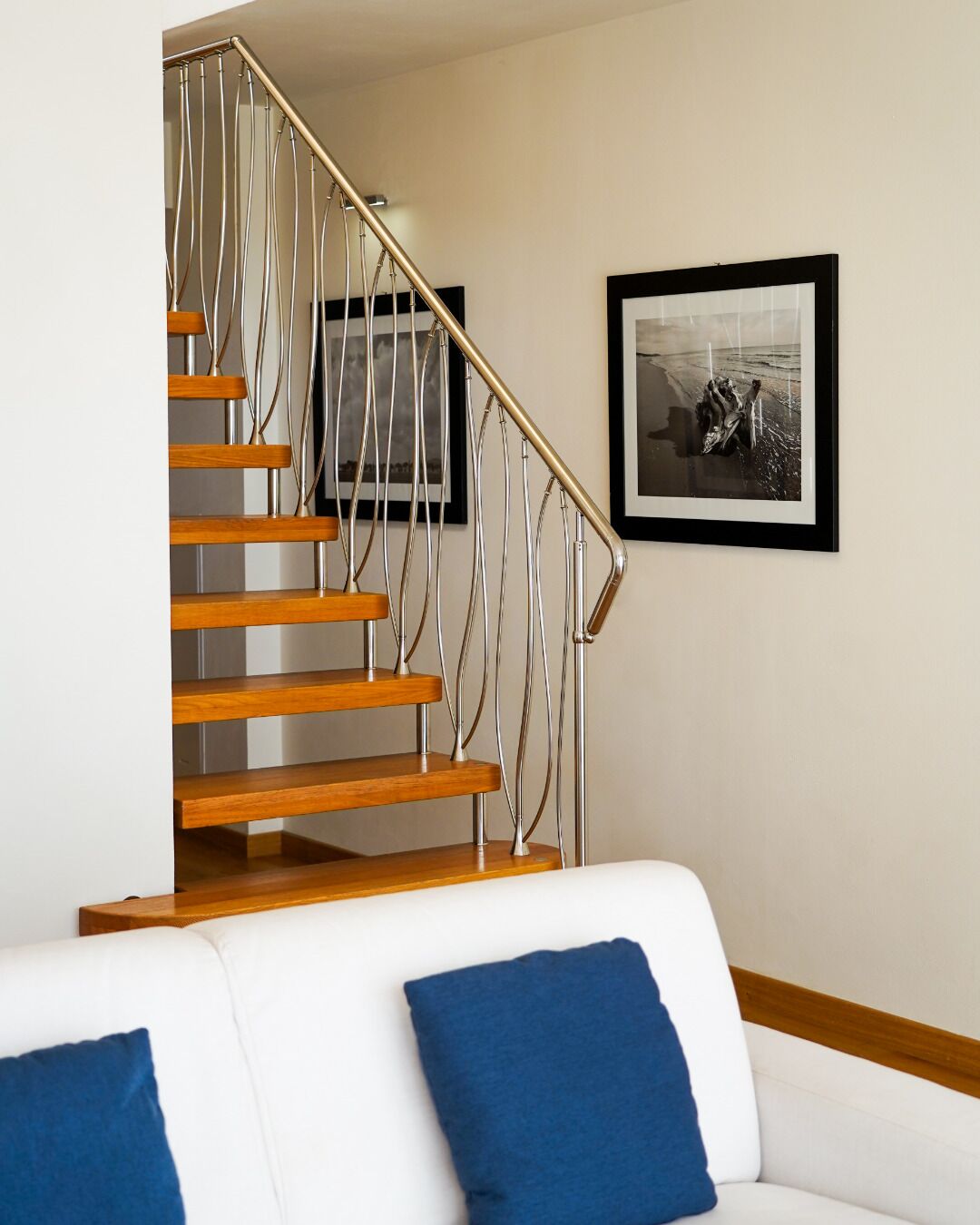 Una escalera de madera con barandilla de metal que conduce a un piso superior.
