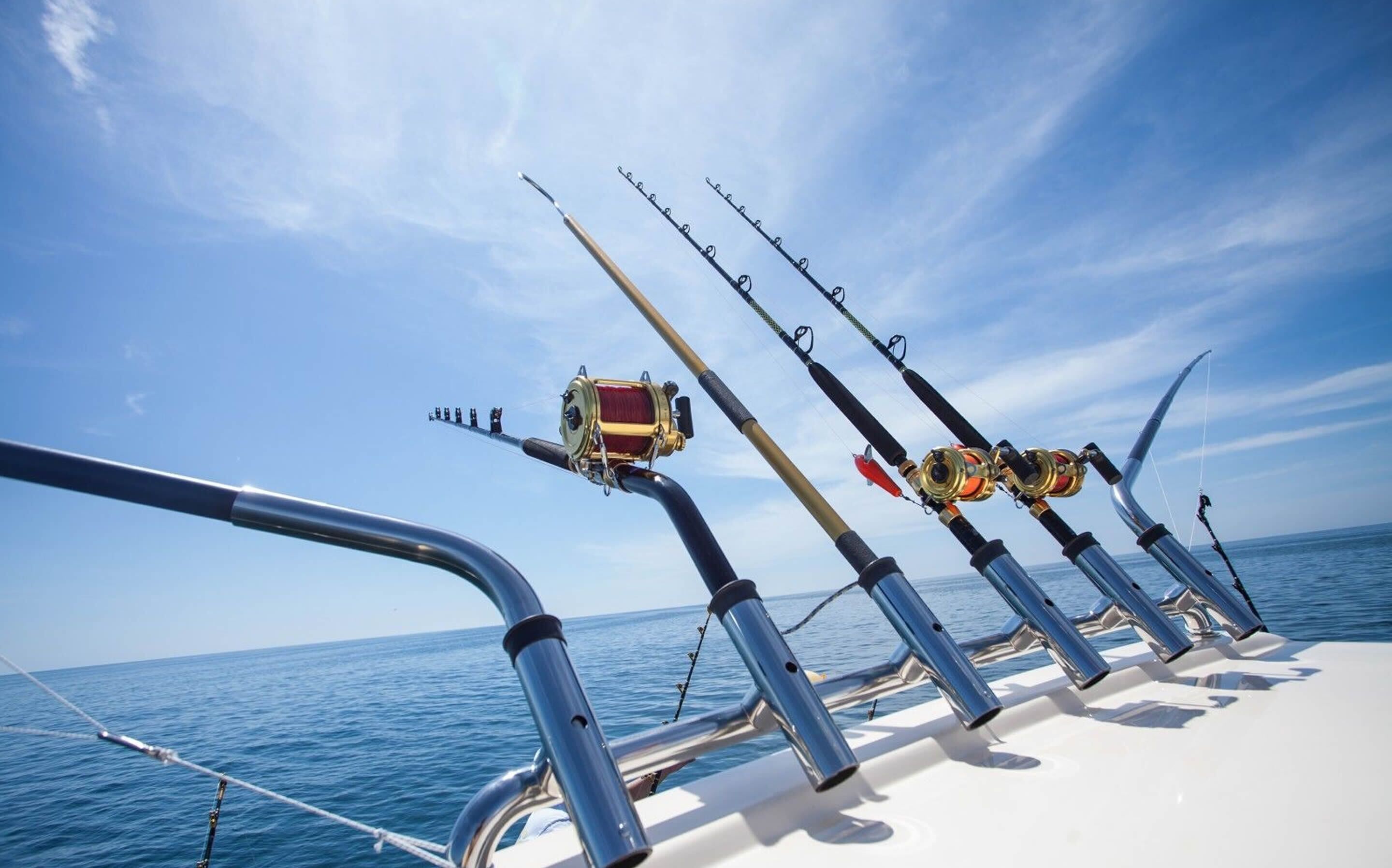 A boat deck with multiple fishing rods and a reel.