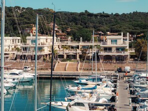 A marina with boats docked, a pedestrian bridge, and buildings in the background. - Marina di Scarlino Resort (Scarlino)