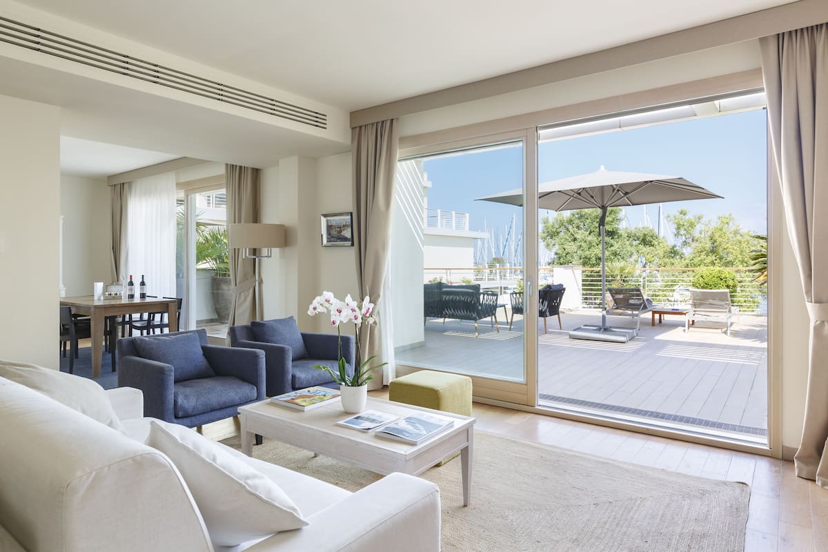 Suite Club, 2 habitaciones, 2 baños, frente al mar | Área de sala de estar | Televisión de pantalla plana de 32 pulgadas con canales por cable