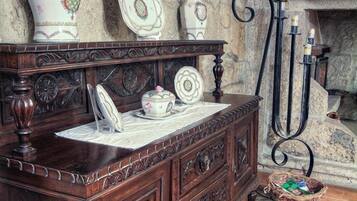 Un meuble en bois orné d’assiettes décoratives et, au-dessus, un tableau représentant des armoiries encadrées.